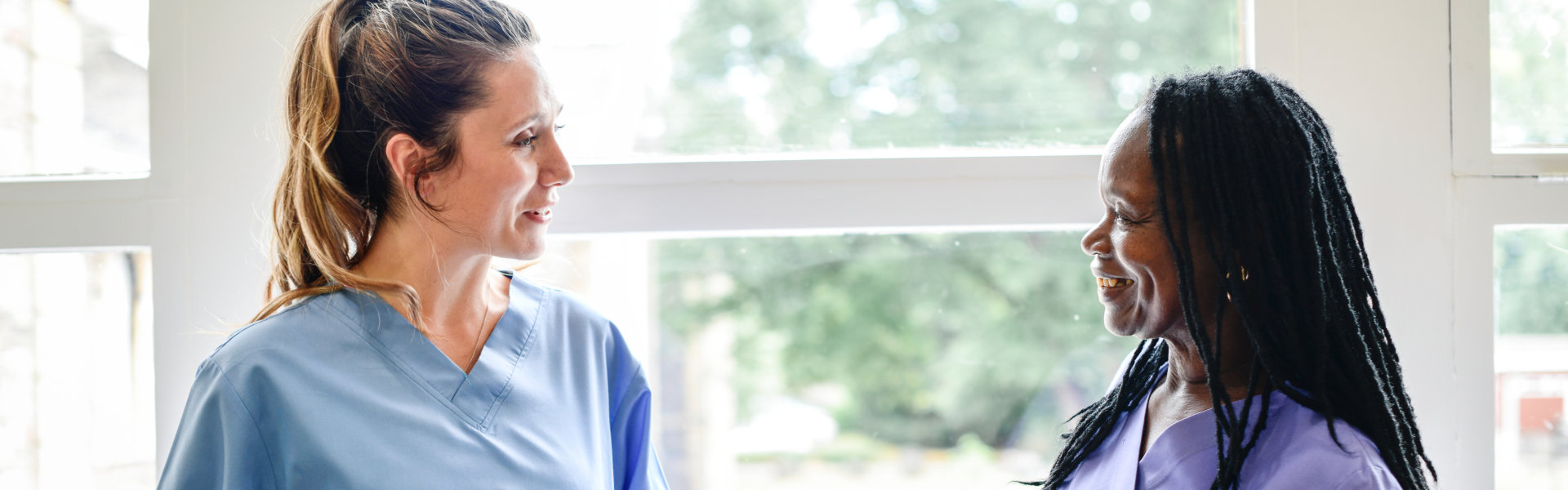 two carers smiling at each other